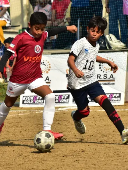 A player skillfully dribbles past a defender. This highlights the technical ability and confidence we instill in our attackers.