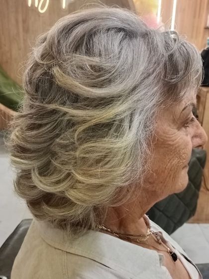 A beautifully styled look for grey hair. The soft waves give it elegance and movement, proving that style is timeless.