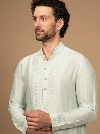 A luxurious pastel green kurta with delicate white embroidery. This piece exudes an aura of royalty and sophistication, perfect for daytime celebrations or destination weddings.
