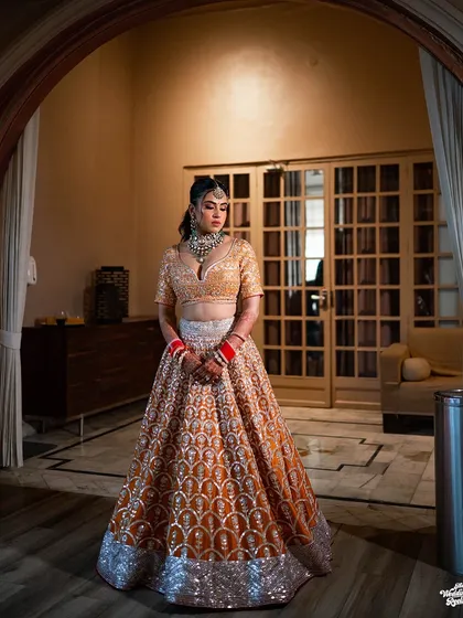 A full-length shot of the bride framed by an archway, creating a classic and elegant bridal portrait.