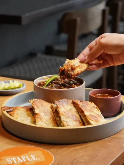 A hearty and traditional plate of chole with kulcha. The styling emphasizes the rich textures of the gravy and the fluffiness of the bread, creating a comforting and appetizing image.