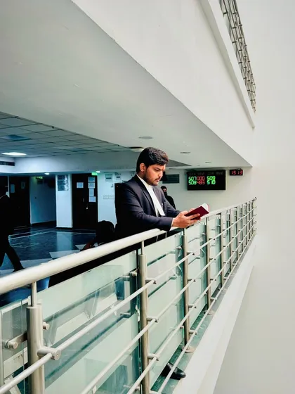 Reading a law book in the court corridor. Those who have substance in their arguments don't need to shout in the courtroom.