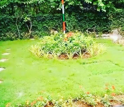 A central landscaped feature with a flag pole, surrounded by a well-maintained lawn and flower beds. This is part of our work creating and maintaining welcoming green spaces for communities.