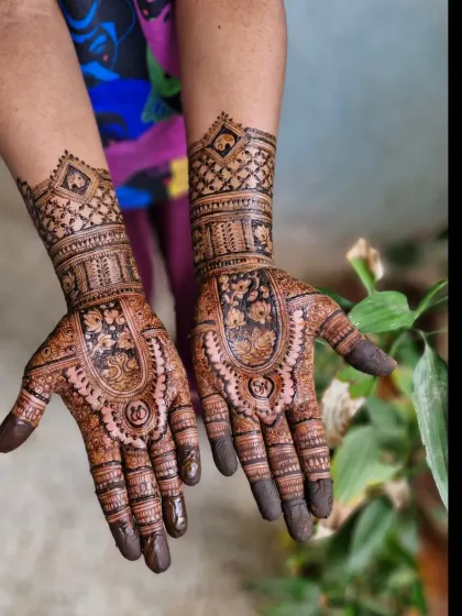 A traditional Rajasthani-style engagement mehendi with initials hidden in the palms. The design features heavy, intricate patterns perfect for a bride.