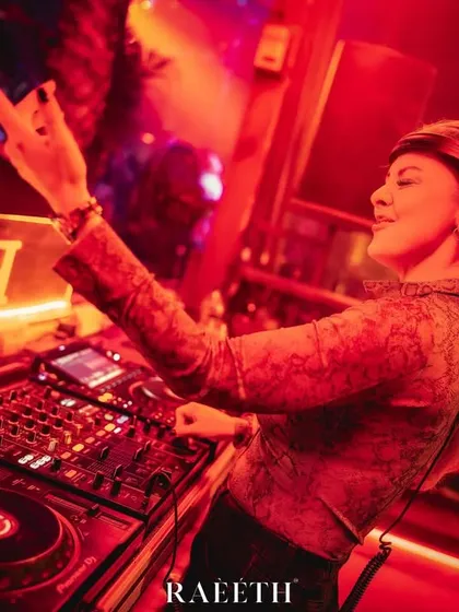 Throwing up a sign of approval to the crowd at Raeeth. The red lighting and intense atmosphere are typical of my club nights.