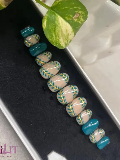 A beautiful set of custom press-on nails featuring a teal and nude design with hand-painted leaves and gold accents. Perfect for a traditional or festive look.