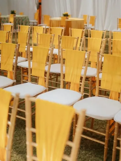 Guest comfort is part of the design. For this outdoor Haldi, I arranged chiavari chairs with bright yellow drapes to match the event's color scheme, ensuring the entire space felt cohesive.