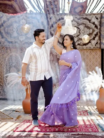 A vibrant and artistic pre-wedding shot. The couple dances in a room decorated with beautiful carpets, creating a unique and colorful backdrop.