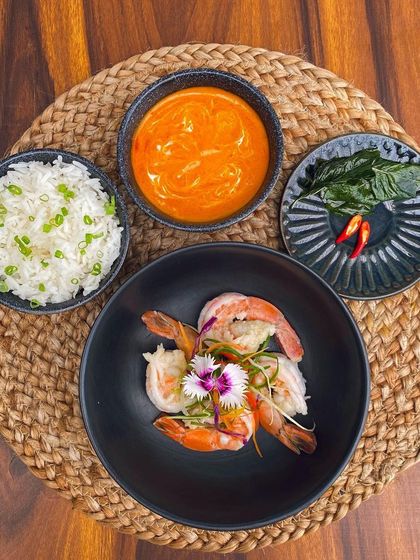 Our Thai Prawns with Red Curry sauce and steamed rice, a deconstructed presentation that allows you to customize each bite.