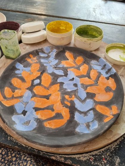 The next step is to apply the base colors. For this plate, I chose a bold combination of orange and blue over a dark background. This layering of colors is what creates the vibrant final look.