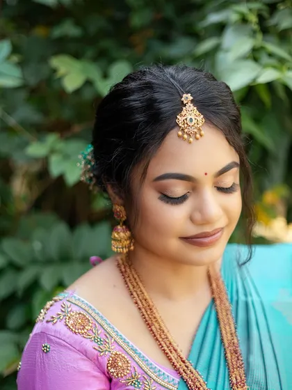 A close-up of Sugirtha's engagement makeup with her eyes closed. The soft, shimmery eyeshadow and defined brows create a polished and elegant look.