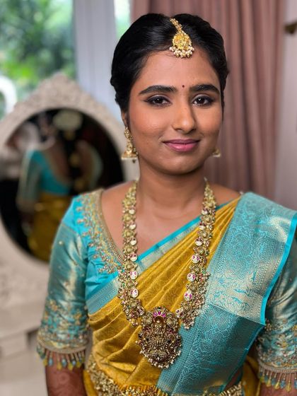 The complete look for Sahithya's muhurtham. The classic winged liner defines her eyes beautifully, and the matte base ensures she looks fresh throughout the ceremony.