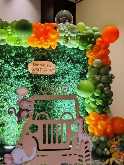 A close-up of our jungle jeep photo-op. This setup for "Sharvil is a Wild One" includes a greenery wall and a fun balloon frame, making it the perfect spot for guests to take memorable pictures.