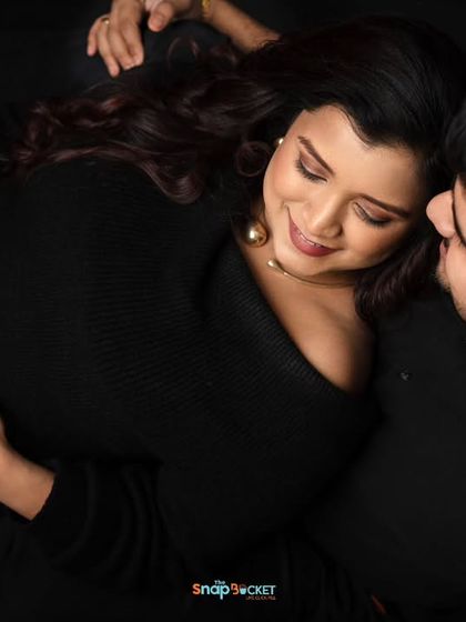 A unique perspective for a couple's portrait. This top-down shot captures an intimate moment as they lie together, focusing on their connection and her beautiful baby bump.