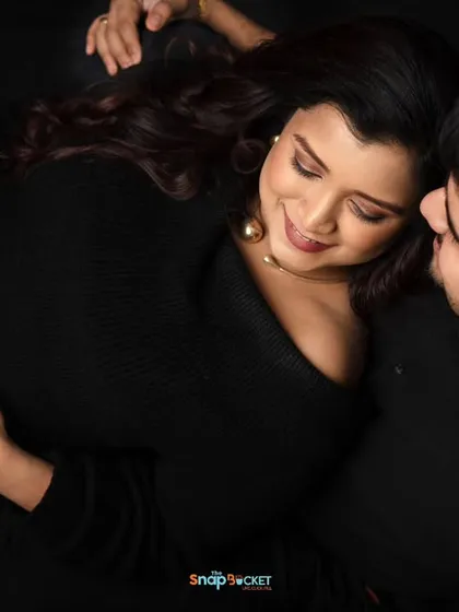 A unique perspective for a couple's portrait. This top-down shot captures an intimate moment as they lie together, focusing on their connection and her beautiful baby bump.