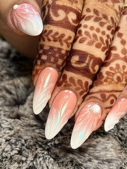 For my brides, I design nails that perfectly complement their henna. This look features a soft airbrushed ombre effect on gel extensions, with a delicate 3D acrylic flower and a single pearl accent for a touch of elegance.
