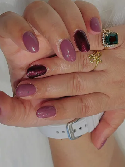 A close-up view of this multi-tonal purple manicure, showing the glossy finish and the contrast between the lighter mauve and the deeper, shimmering berry shade.