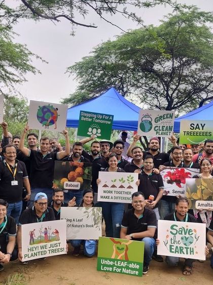 The Colt Technology Services team celebrates their successful plantation drive, holding signs that read "Save the Earth" and "Let's Plant a Forest Together."