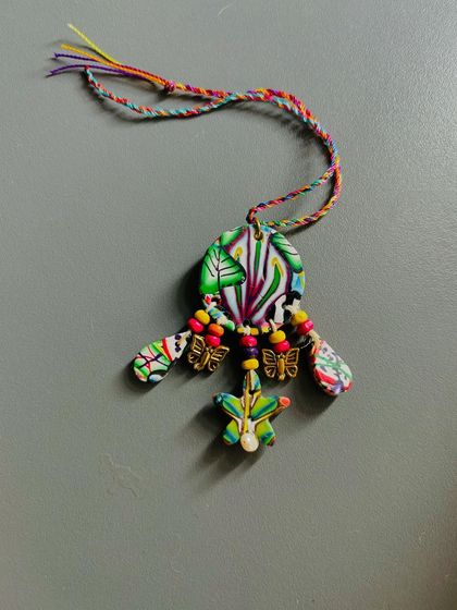 This is an exquisite Lumba I made for the Rakhi season. It's crafted from clay and decorated with wooden beads, delicate butterfly embellishments, and a real pearl.