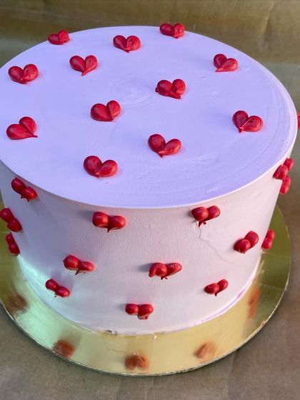 A lovely cake adorned with a pattern of tiny red hearts. This design is perfect for Valentine's Day, anniversaries, or any romantic occasion.