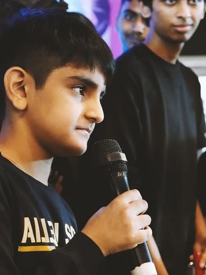 One of our young vocalists confidently addressing the audience during a live band performance. Public speaking and stage presence are valuable skills we nurture.