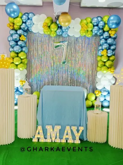 A cricket-themed birthday party for an Amay. The decor features a green turf base, cutouts of cricket stars, and a balloon arch in team colors, perfect for a young sports fan.