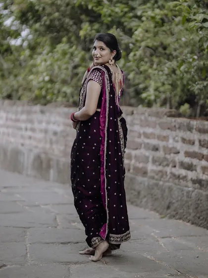 A graceful pose in a traditional Navari saree. This shot from behind shows the elegant drape and rich color of this beautiful Maharashtrian outfit.