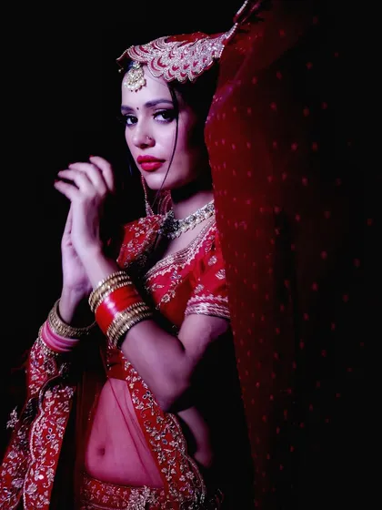 This portrait uses high contrast lighting to create a bold, edgy look. The deep shadows and the bride's pose give the image a strong, unconventional feel.