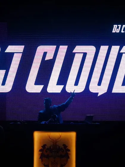 On stage is where I belong. This shot captures me in my element, silhouetted against my logo, ready to take the crowd on a musical journey. It's just me, the decks, and the music.