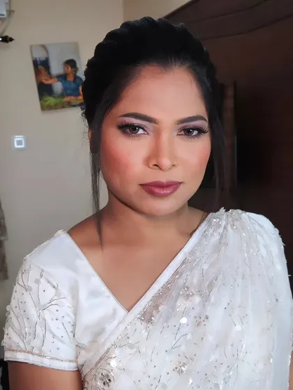 A beautiful Christian wedding look with a white saree. The makeup is glamorous yet elegant, with a focus on the eyes.