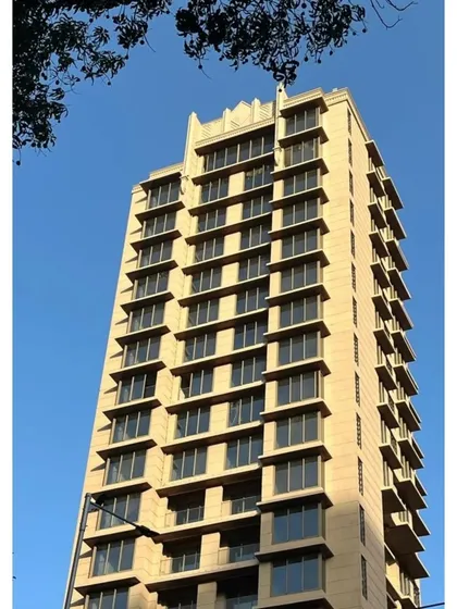 The strong, clean lines of this residential tower against a clear blue sky. The facade's rhythmic pattern of windows and balconies creates a sense of order and modern elegance.