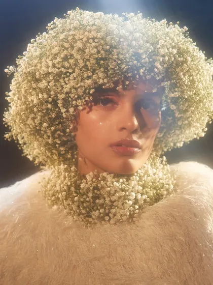 An ethereal and angelic look, with the model's hair styled into a cloud of baby's breath.