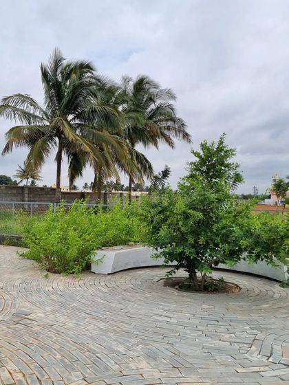 This work-in-progress shot shows a seating area in a small residential community. A curved stone bench is integrated with a circular paving pattern, creating a natural spot for residents to gather.