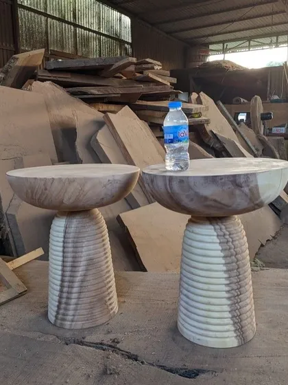 A pair of ribbed, bowl-shaped side tables, unfinished to show the natural wood grain.