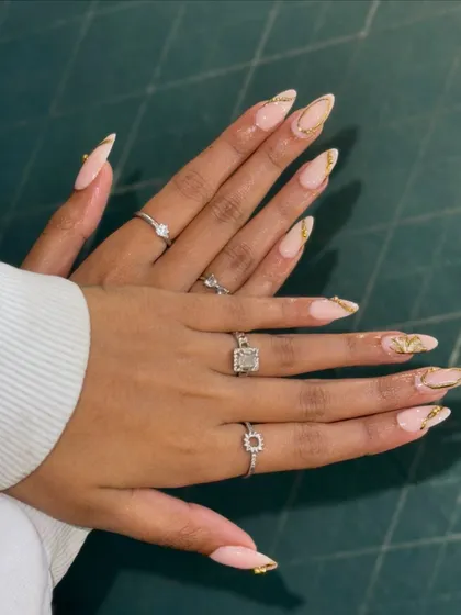 Get a closer look at this elegant nail set. I've crafted these long, almond-shaped extensions with a soft nude base and finished them with delicate gold foil accents. It's a perfect example of custom nail art that's both classy and on-trend.