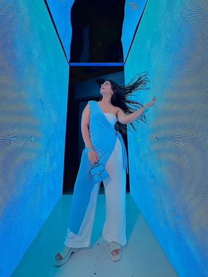 Having a fun, hair-flipping moment at a brand event. This stylish blue and white outfit was perfect for the occasion, combining a chic one-shoulder top with wide-leg pants.