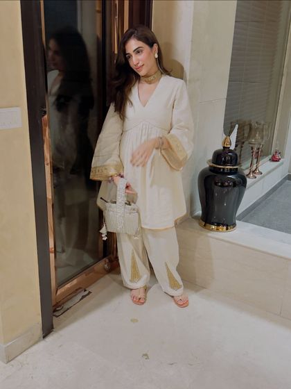 Another angle of the off-white Rakhi suit, paired with a delicate choker and a beaded bag. The details make all the difference.