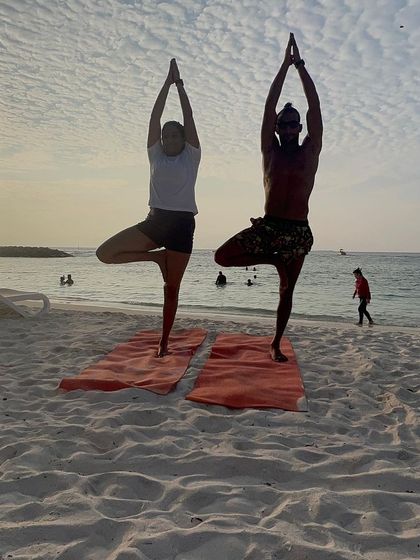 Finding our balance together with Vrikshasana (Tree Pose) as the sun sets over the ocean. Practicing with a partner brings a sense of shared focus and stability.
