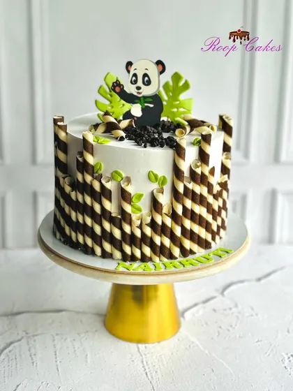 A cute little panda theme cake, with chocolate-striped wafer rolls creating a bamboo-like effect.