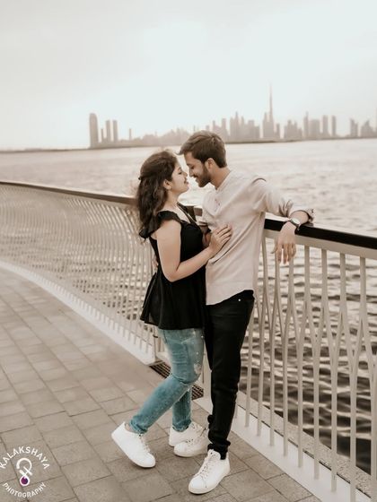 A romantic moment with the Dubai skyline in the background, captured from a waterfront promenade.