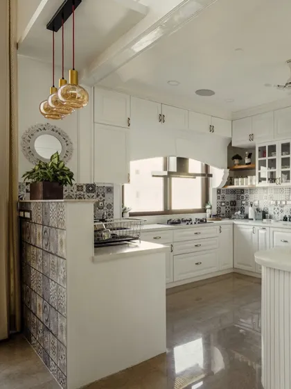 A view of the all-white kitchen from image 148, showing the Moroccan-inspired tile backsplash and island partition.