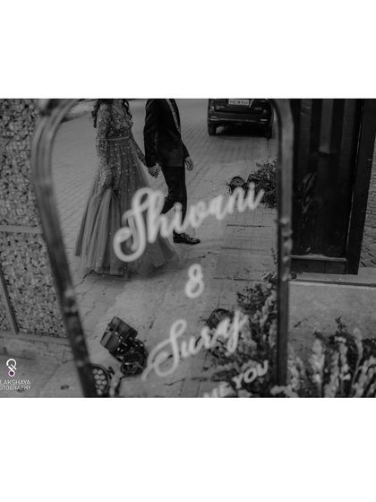 A black and white shot capturing the reflection of the couple's name on a mirror at their reception.