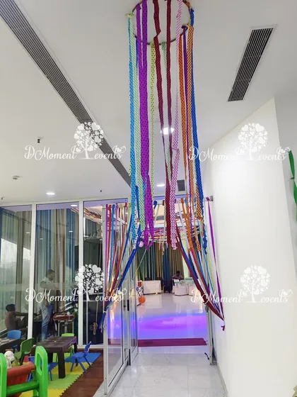 An entrance to an Art & Craft themed party, featuring a colorful ribbon curtain that guests can walk through.