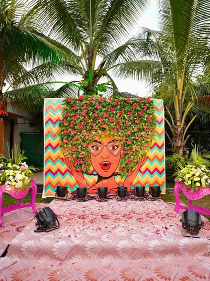 A quirky and artistic backdrop for a fun-filled Mehendi. This hand-painted mural with a 3D floral hairstyle is a great example of how we bring unique, personalized ideas to life for a truly memorable event.
