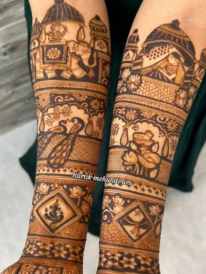 The upper arms of a bridal mehandi, featuring a baraat scene, peacocks, and other traditional figures. Every inch of the design is filled with beautiful, meaningful art.