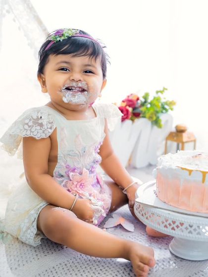 The happiest cake-covered smile you'll ever see. This little one is loving her first birthday cake smash, set against a beautiful, rustic teepee backdrop.