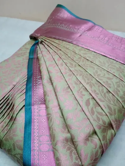 A pastel green and pink brocade saree, with pleats customized to the client's physique.