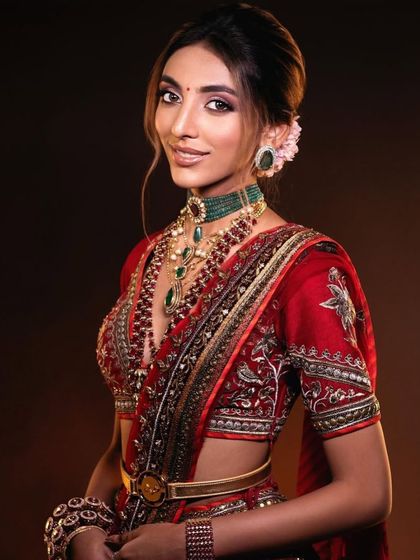 Another angle of the classic red bridal look, showing the beautiful details of the jewellery and the way the makeup enhances the bride's features.