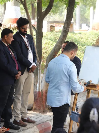 Beginning the landscape painting, with faculty and students observing the initial stages.