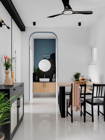 A simple archway painted in a contrasting blue frames the view into the powder room, turning a simple transition space into a design feature.